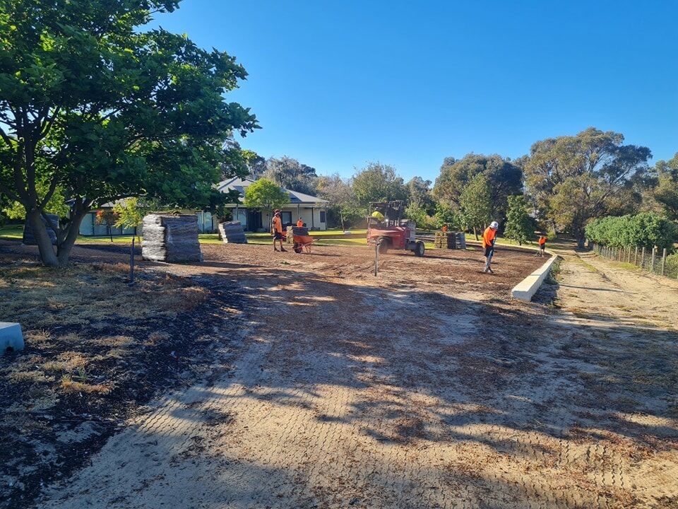 Country Landscaping & Irrigation crew installing a limestone retaining wall on a South West WA property